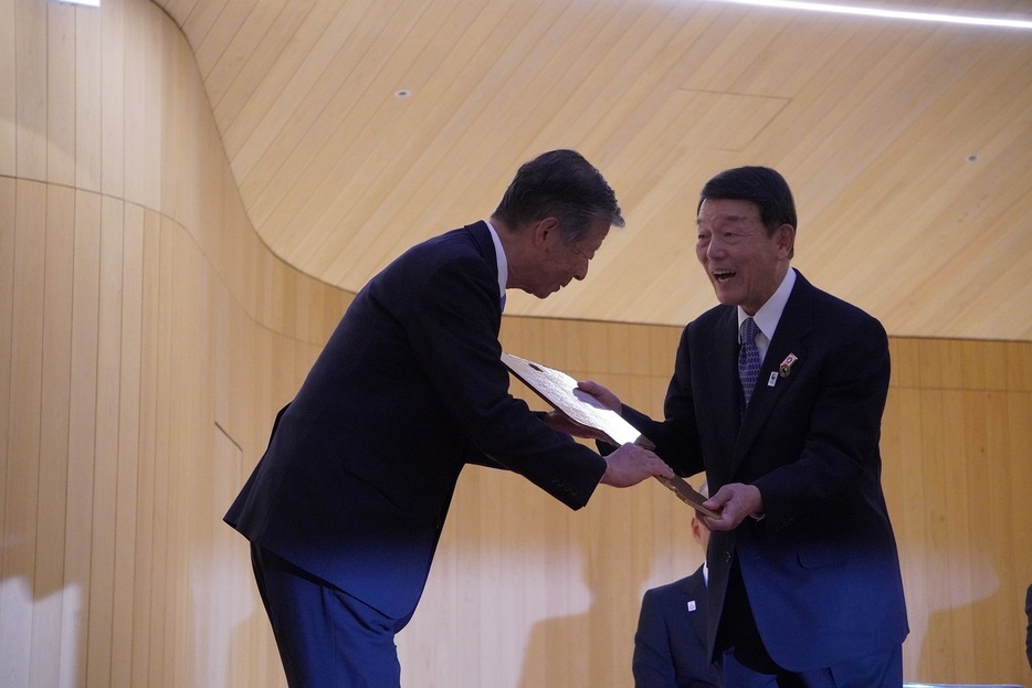 難波会長(左)が西澤副代表理事に鍵を引き渡した