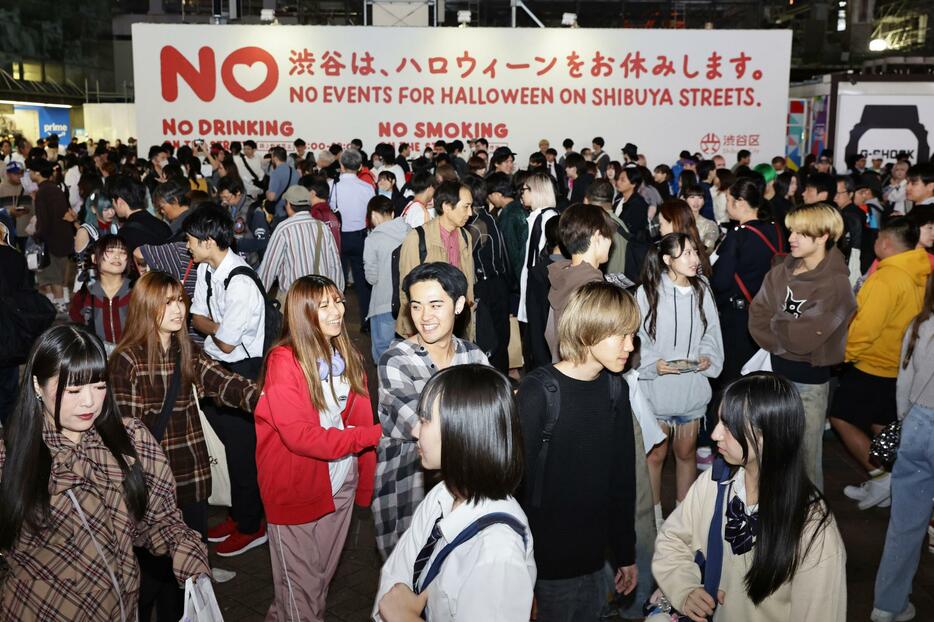 ハロウィーン直前の週末、東京・渋谷駅前を行き交う人たち＝26日夜