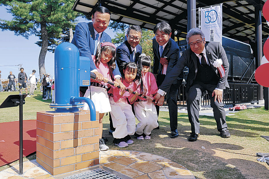 手押しポンプを操作する藤井市長（左）ら関係者と子ども＝富山市の牛島公園