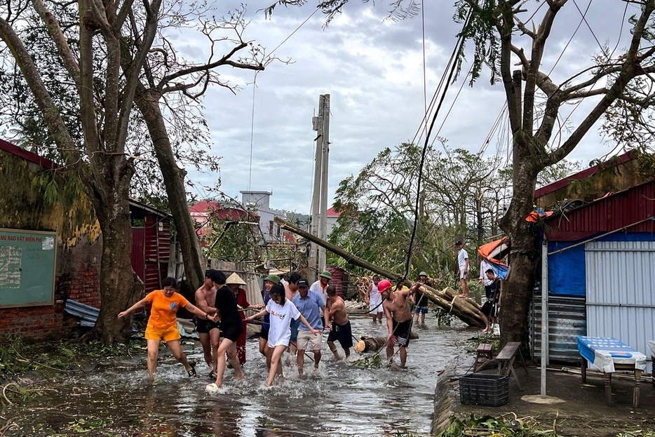 台風11号による倒木をロープを使って撤去する人たち＝9月、ベトナム・ハイフォン（ロイター＝共同）