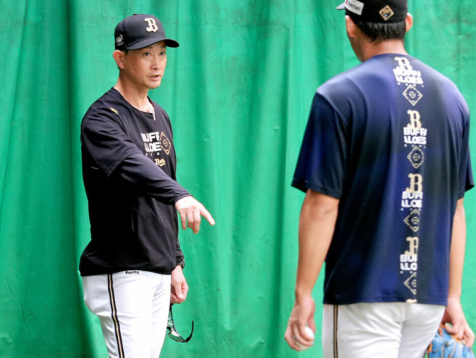 ブルペンで佐藤（右）にアドバイスを送るオリックス・岸田新監督