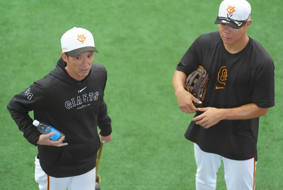 佐々木俊輔（右）と話す松本哲也外野守備走塁コーチ（カメラ・岡野　将大）