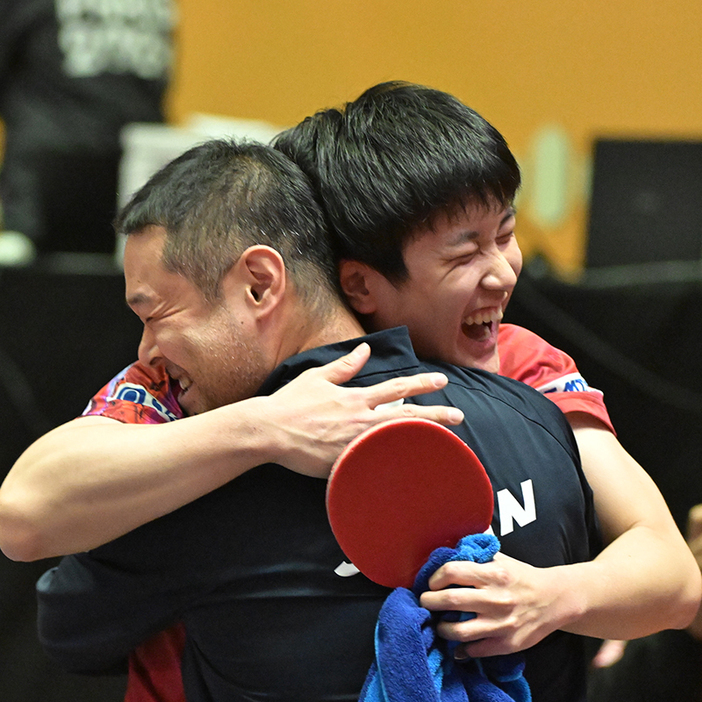 アジア選手権初優勝を決め、ベンチの田勢邦史監督と抱き合う張本智和（PHOTO：ATTU）