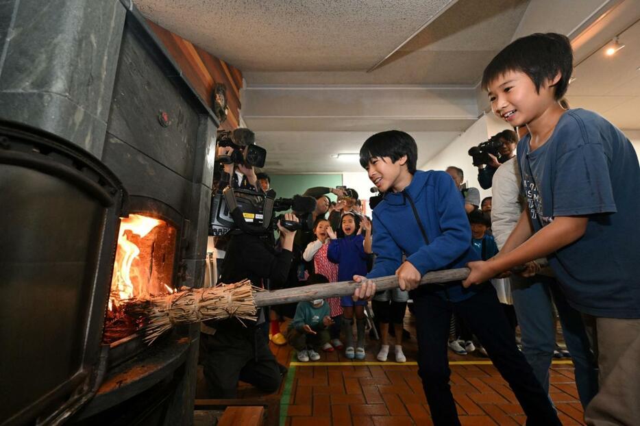 まきストーブに火を入れる児童たち＝２３日午前、神戸市灘区六甲山町、六甲山小学校（撮影・大田将之）