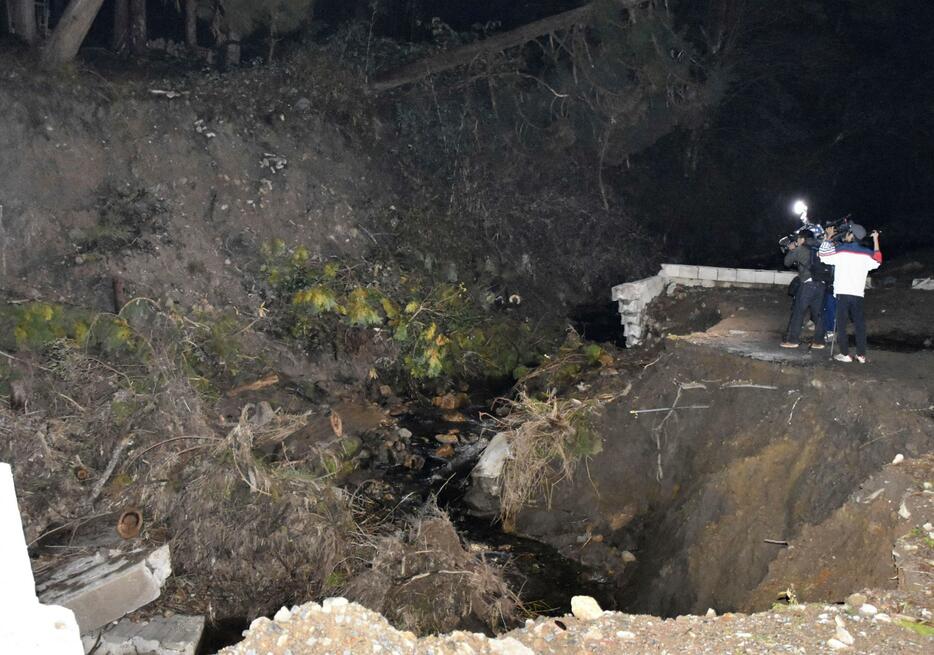 橋の付近にたまった土砂の中から心肺停止の状態の人が見つかった現場＝24日午後、石川県能登町