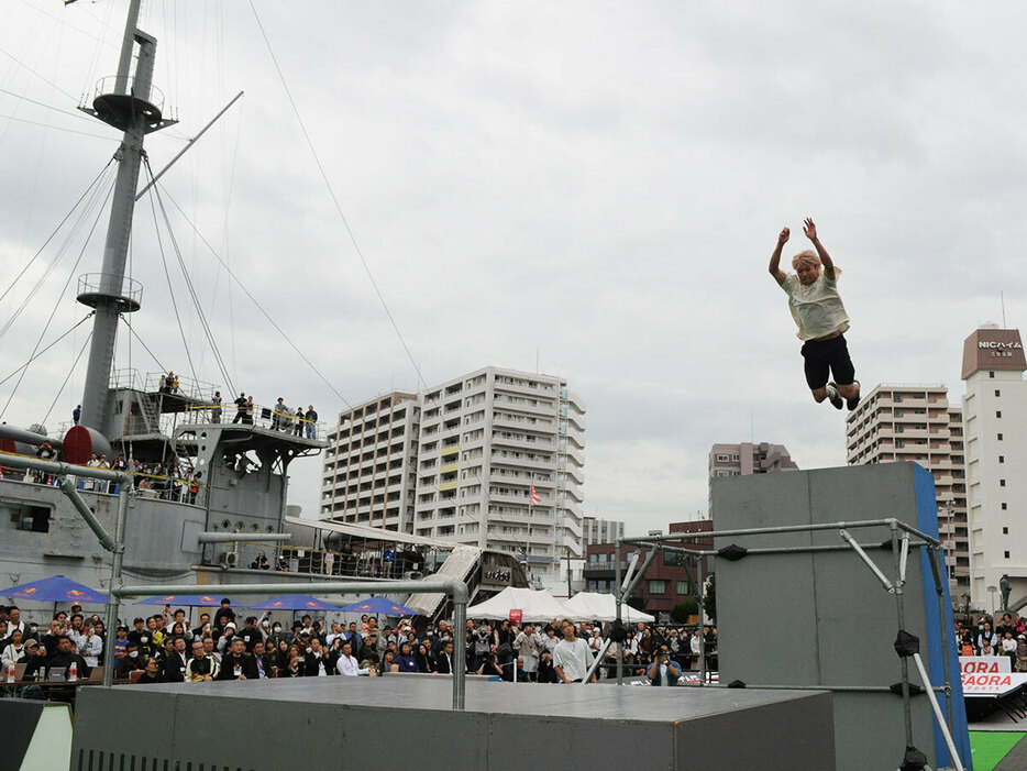 ３メートル以上の高さの壁からジャンプする選手＝２６日、横須賀市の三笠公園