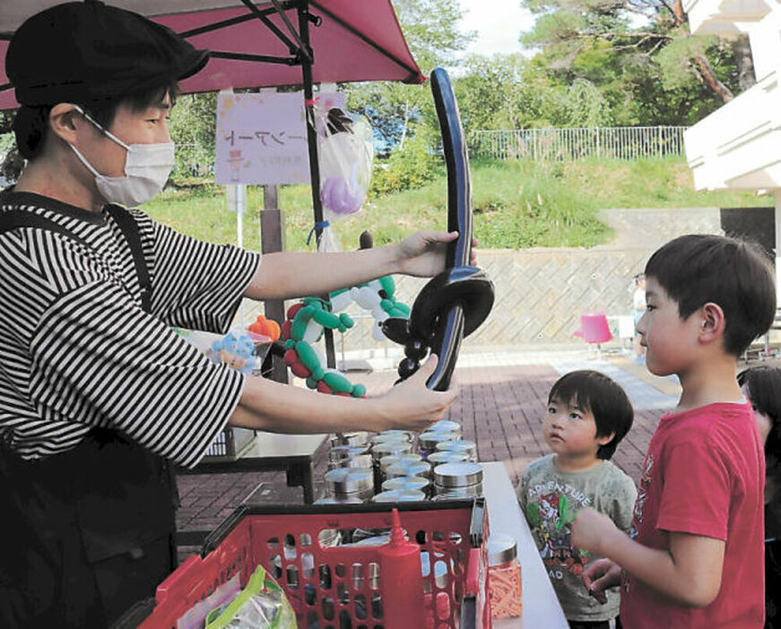 風船を手渡す斎藤さん。子どものリクエストに応えて剣を作った