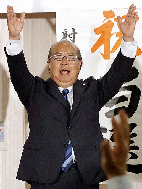 県知事選で再選を確実にし、万歳する新田八朗氏＝２７日夜、富山市