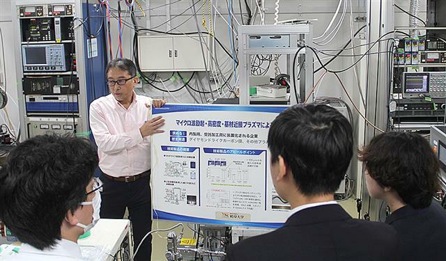 岐阜大学で取り組むプラズマ応用研究の説明を受ける参加者たち