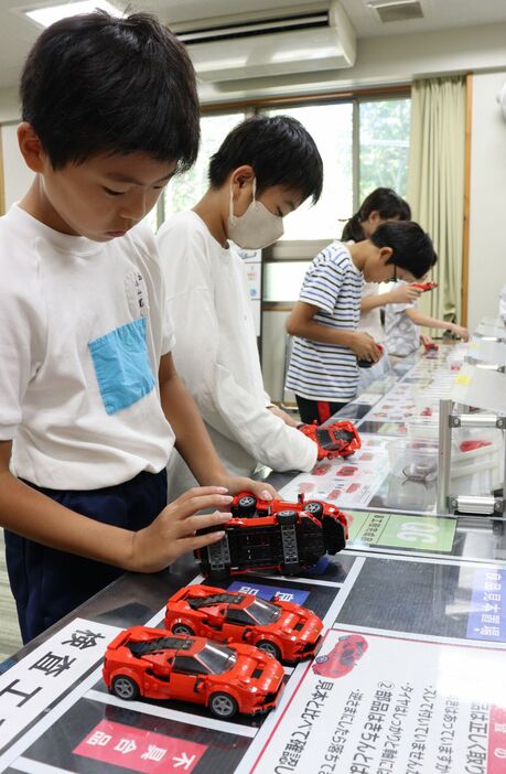 車の模型を組み立てるライン作業を体験する児童たち（京都府向日市・向陽小）