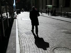 A pedestrian walks along Wall Street. Photographer: Michael Nagle/Bloomberg