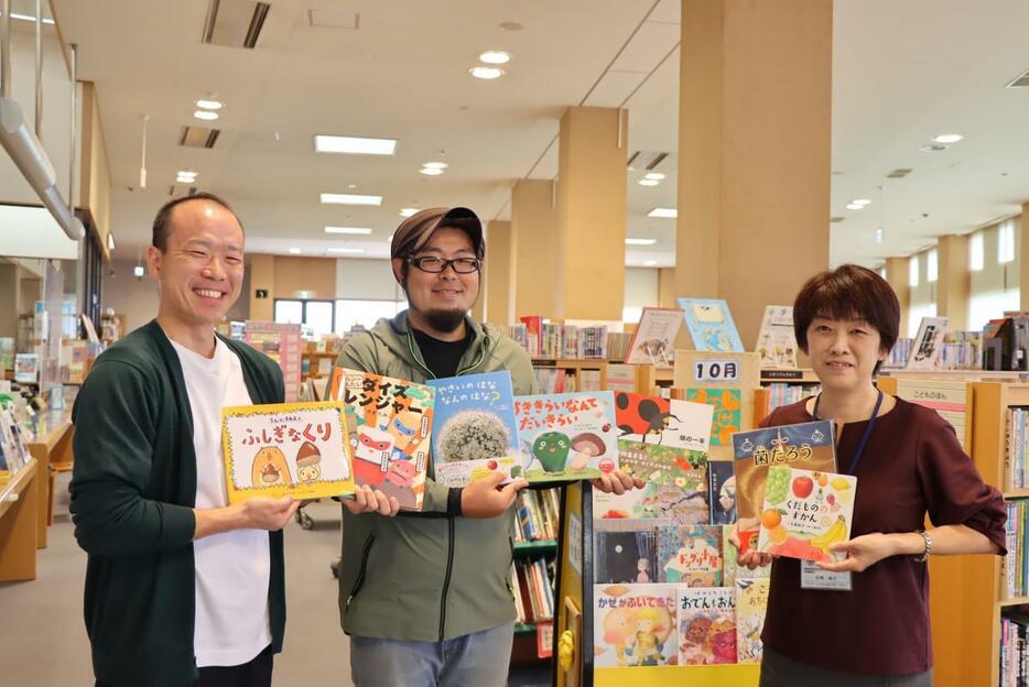 （左から）図書館で絵本を寄贈するHAERUマーケット事務局の斉藤さん、萩谷さん、絵本を受け取る館長の石崎さん（写真提供＝茨城町）