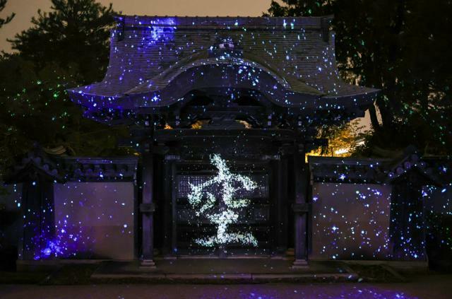 高台寺の勅使門に、星空に浮かび上がるように「空」の文字が映し出された=2024年10月23日午後5時58分、京都市東山区、新井義顕撮影