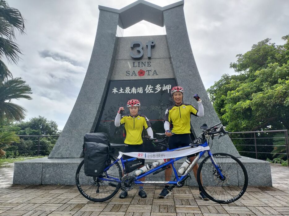 ゴール地点の佐多岬に到着し、ガッツポーズする翔生さん(左)と顕正さん=鹿児島県南大隅町(阪野さん提供)