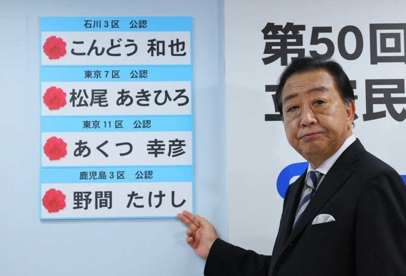 当選確実となった候補者の名前を前に記念撮影に応じる立憲民主党の野田佳彦代表＝東京・永田町の同党本部で2024年10月27日午後8時53分、長谷川直亮撮影