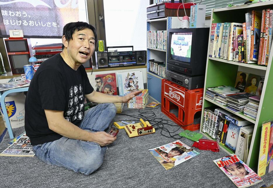 1980年代を再現した部屋のファミリーコンピュータで遊ぶ「昭和サブカルチャーミュージアム」の五十嵐良二館長＝9月7日、山形県鶴岡市