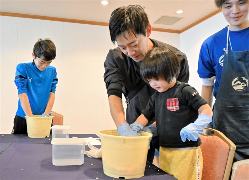 力を合わせてみそ作りに挑戦する親子