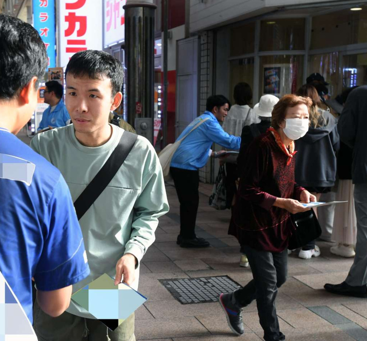 繁華街で最後の支持を訴える候補者（左）＝２６日、鹿児島市千日町（画像は一部加工してあります）