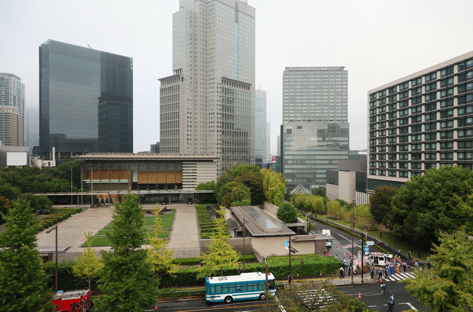 首相官邸（左）付近のバリケードに突っ込んだ車両（右下）＝１９日午前、東京・永田町