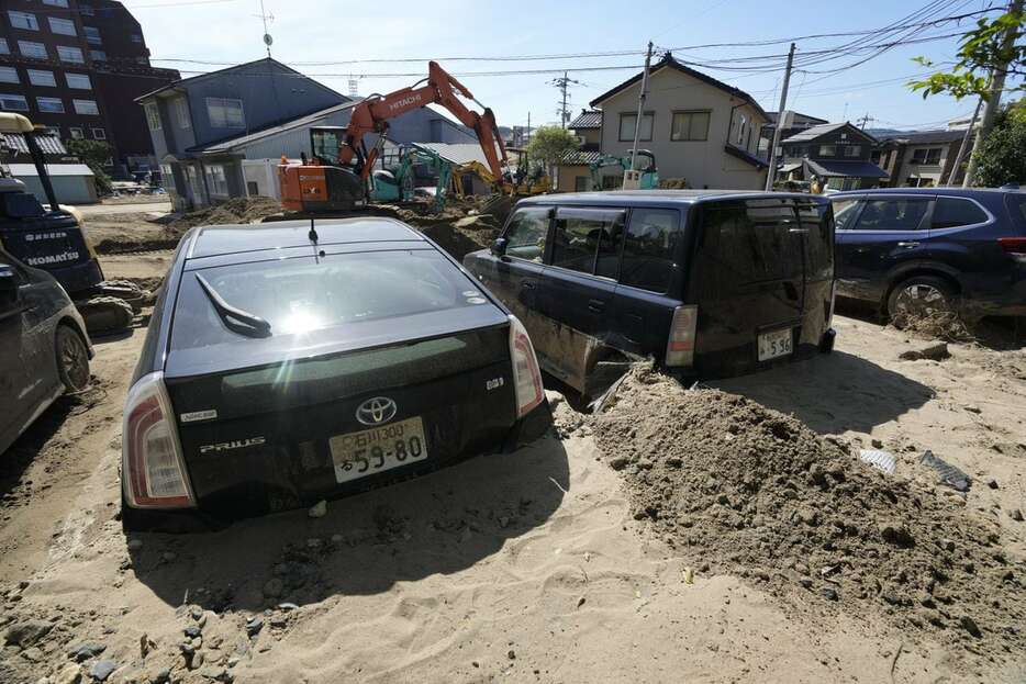 グラウンドから流出した砂に埋まった車両＝9月27日、石川県輪島市杉平町（甘利慈撮影）