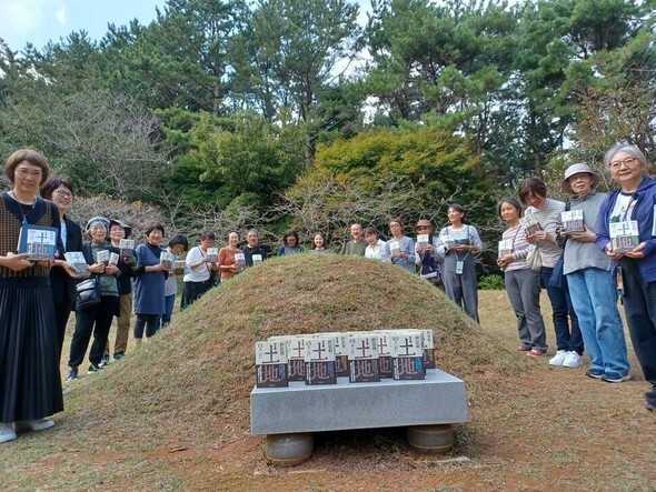 今月19日午後2時ごろ、日本の読者たちが朴景利の墓を囲み、日本語版が完成した『土地』20巻をささげた。左端が共同翻訳家の一人、清水知佐子さん。その右がクオンの金承福代表=イム・インテク記者