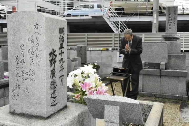 水野広徳の墓前で手を合わせる参列者＝19日午前、松山市柳井町3丁目