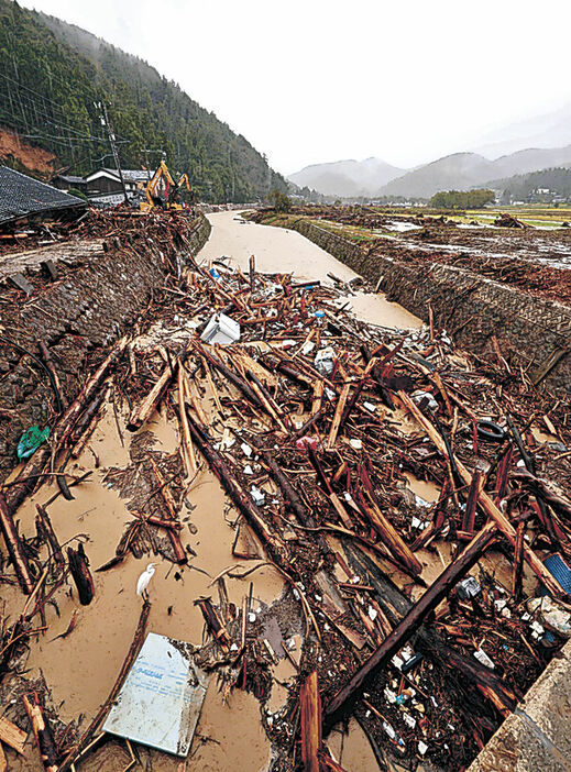 鈴屋川下流に押し寄せた流木。川の流れを妨げていた＝７日、輪島市町野町