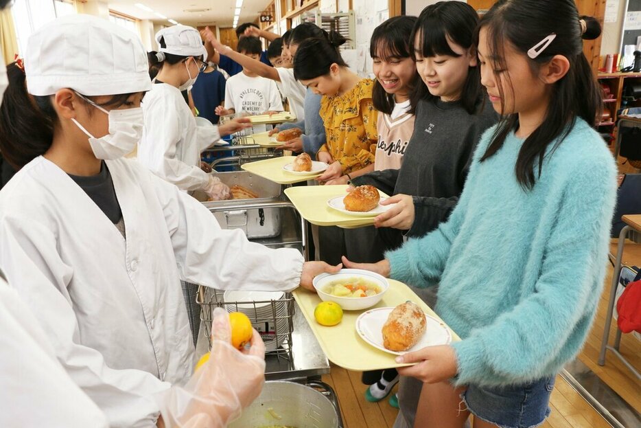 かっぽう着姿の給食当番が順番に盛りつける＝東京都大田区立嶺町小学校、米倉昭仁撮影