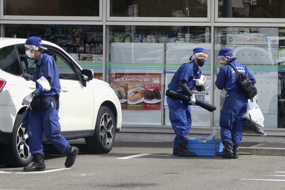 男性が刺される事件があったコンビニを調べる捜査員＝22日午前、名古屋市中村区