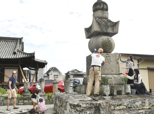 【高虎公の墓石や周辺を清掃する会員ら＝津市寿町の寒松院で】