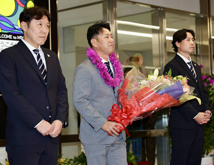 宮崎空港に到着し花束を受け取る井端弘和監督(左は村田善則コーチ、右は亀井善行コーチ)(カメラ・小林　泰斗)