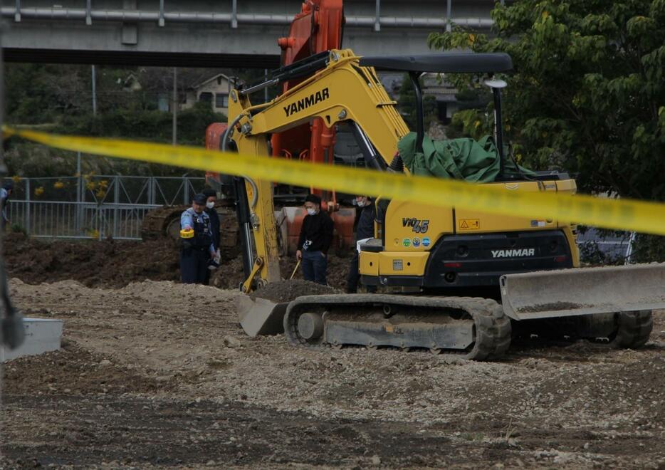 規制線の向こうで事故が起きた現場を調べる警察官たち＝丹波市氷上町大崎