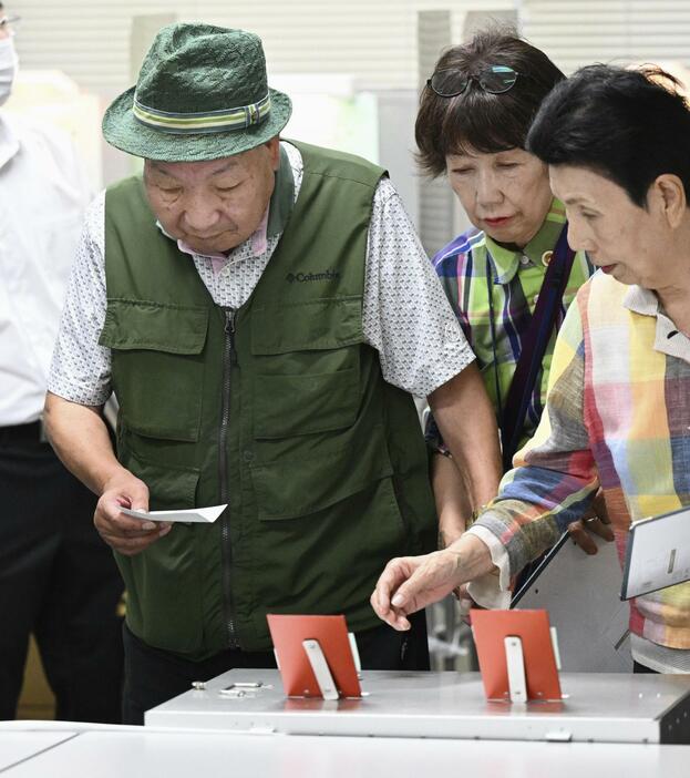 衆院選の期日前投票をする袴田巌さん（左）。右は姉ひで子さん＝25日午後、浜松市役所