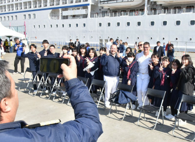 外国客船のクルーと写真撮影する河南中の生徒