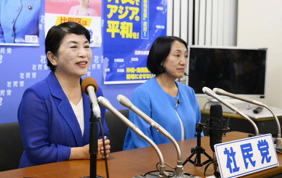 記者会見する社民党の福島党首（左）＝27日午後8時22分、東京都中央区