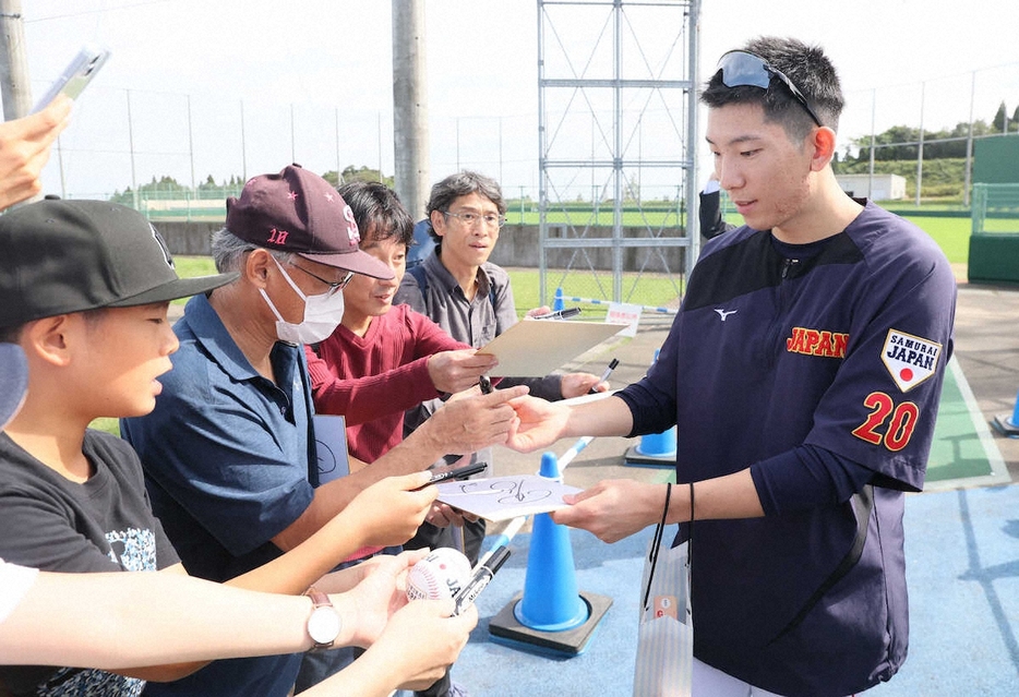 ＜侍ジャパン合宿　2日目＞ファンからの求めに応じてサインする戸郷（撮影・岸　良祐）