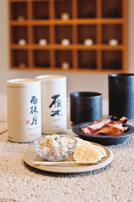 『PRIME　SAKE　Tokyo　Haneda　Airport』（料理：手前）おつな実山椒　880円、（料理：奥）生ハムのような鰹節食べる削り節　550円、（ドリンク：左）雨後の月ぐい呑み　1100円、（ドリンク：右）雁木片口　1870円　国内からセレクトしたこだわりのおつまみとのペアリングも楽しみ