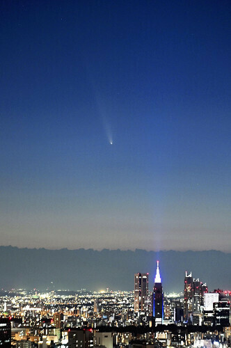 新宿のビル群上空に姿を現した「紫金山・アトラス彗星」（中央）。（１３日午後６時５分、東京都千代田区で）＝上甲鉄撮影