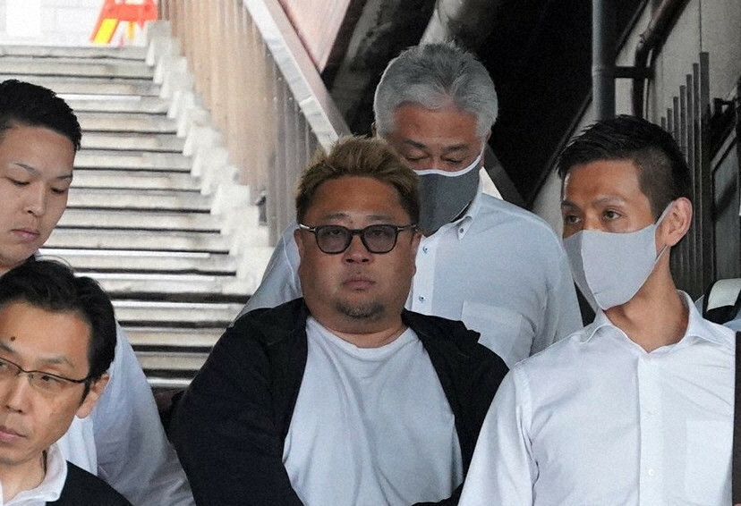 大阪府警の捜査員とともに新大阪駅に到着した池田友喜容疑者（中央）＝大阪市淀川区で2024年10月30日午後0時2分、岩本一希撮影