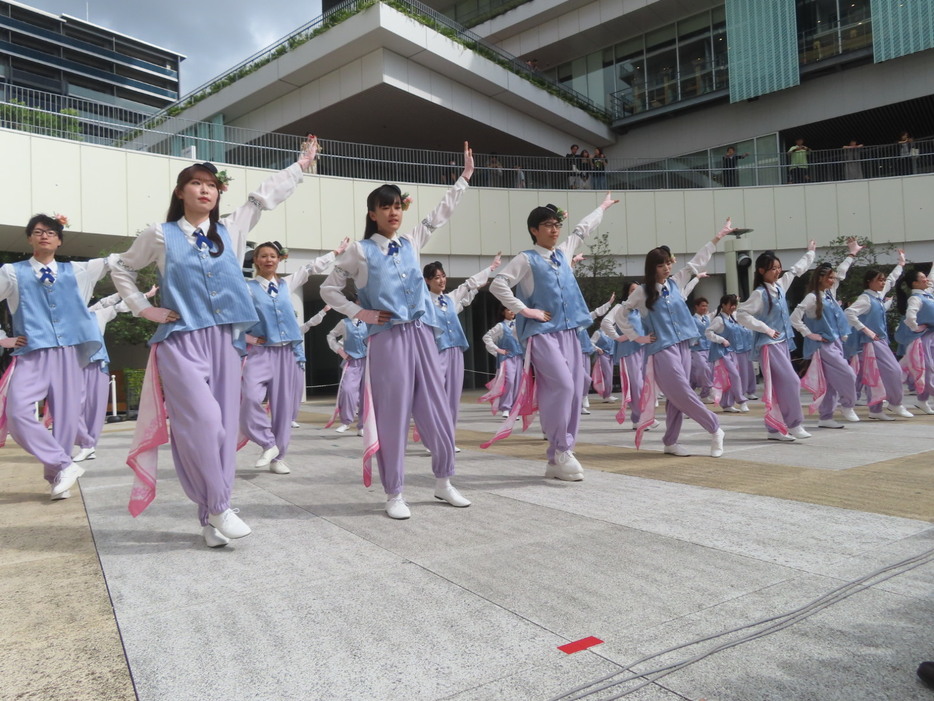 オープニングで踊るアンバサダー＝まちなか広場で