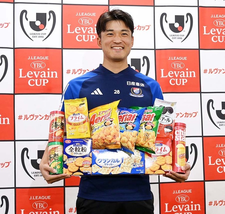 ビスケットや菓子を手に笑顔の横浜Ｍ山根＝Ｆ・マリノススポーツパーク