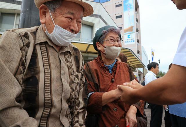 有権者と握手する候補者＝２６日午後、延岡市