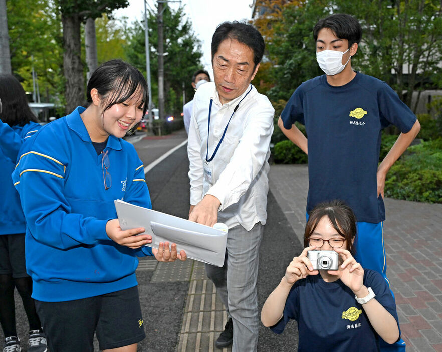 佐藤代表（中央）と一緒に古い写真の撮影地点を巡る生徒＝仙台市青葉区の愛宕上杉通