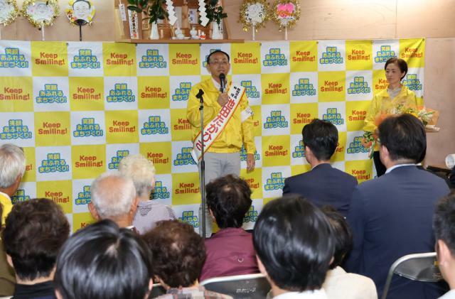 無投票での４選を決め、選挙事務所で支援者を前にあいさつする池田宜永さん（中央）＝２０日午後、都城市太郎坊町