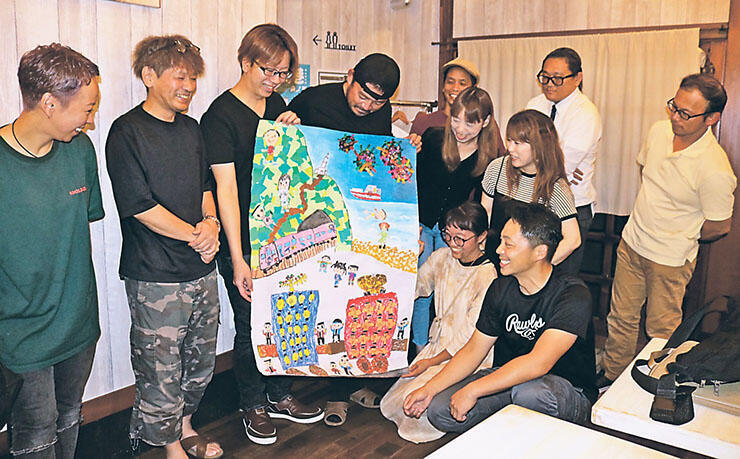 イベントポスターの原画を手にする実行委員会メンバー