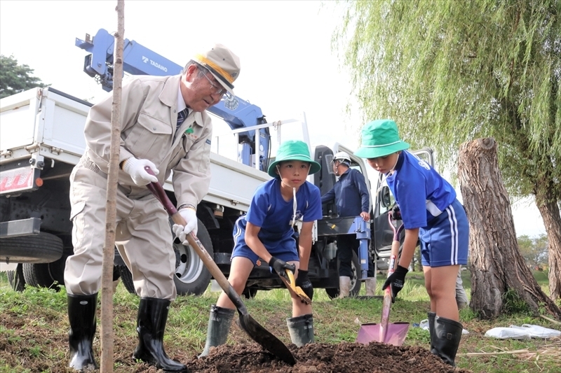 ソメイヨシノの苗木を植える遠藤市長（左）と団員