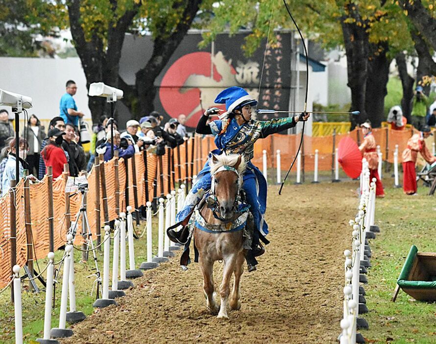 疾走する馬上から的を狙い矢を放つ騎手