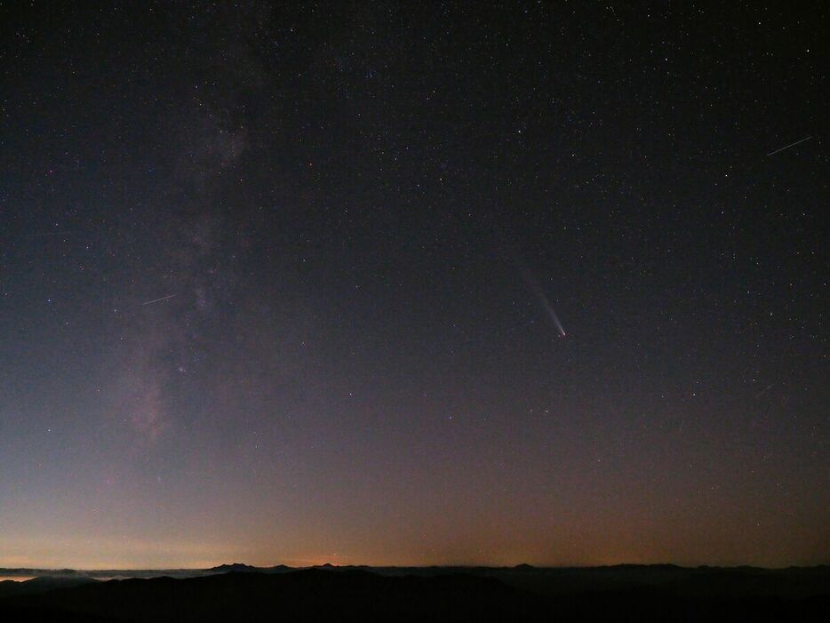 朝日岳山頂から西の空に輝く天の川と、長い尾を引く紫金山・アトラス彗星（中央右）＝２０日午後６時３９分、那須町湯本、田崎さん撮影