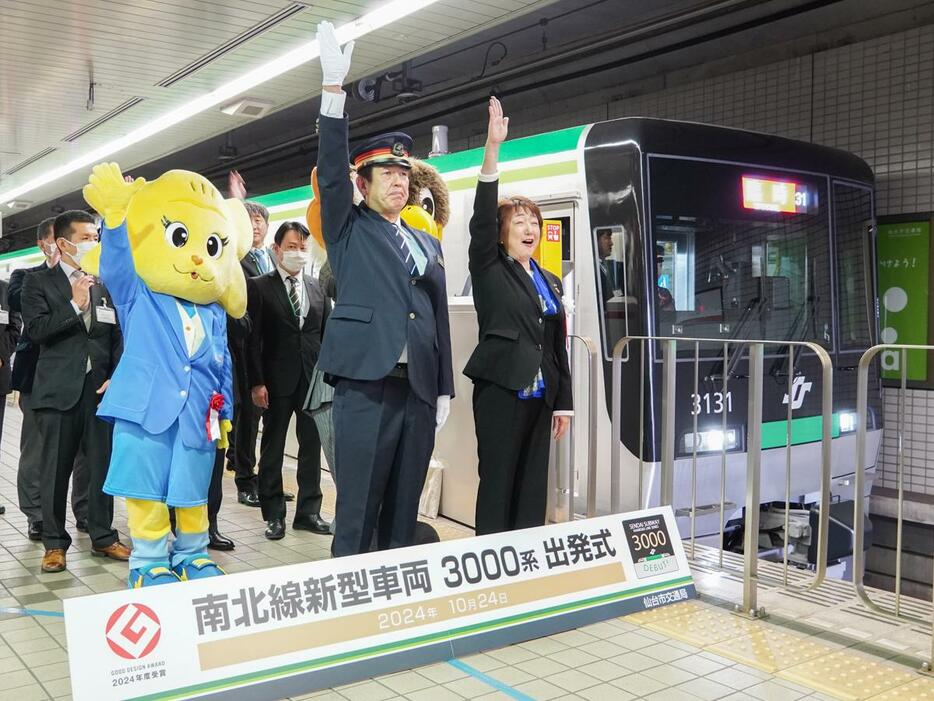 運行初日には仙台市地下鉄泉中央駅で出発式を開いた。発車合図を行う（手前右から）郡和子仙台市長、勾当台管区駅長の佐藤俊也さん、マイナビ仙台レディースのマスコット「マイビィ」