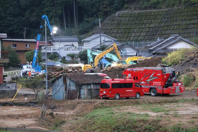 土砂崩れ現場で行方不明となっている住民を捜索する隊員ら＝２４日午後、延岡市浦城町